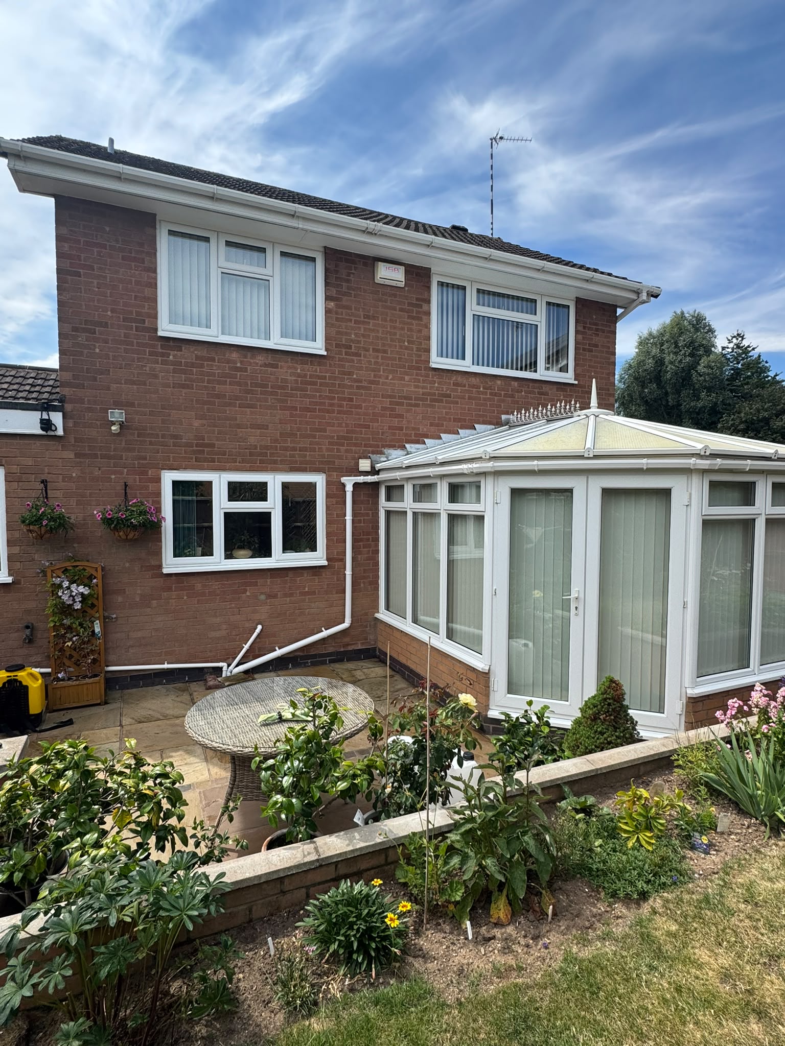 Rear of house with spotless conservatory and sandstone patio