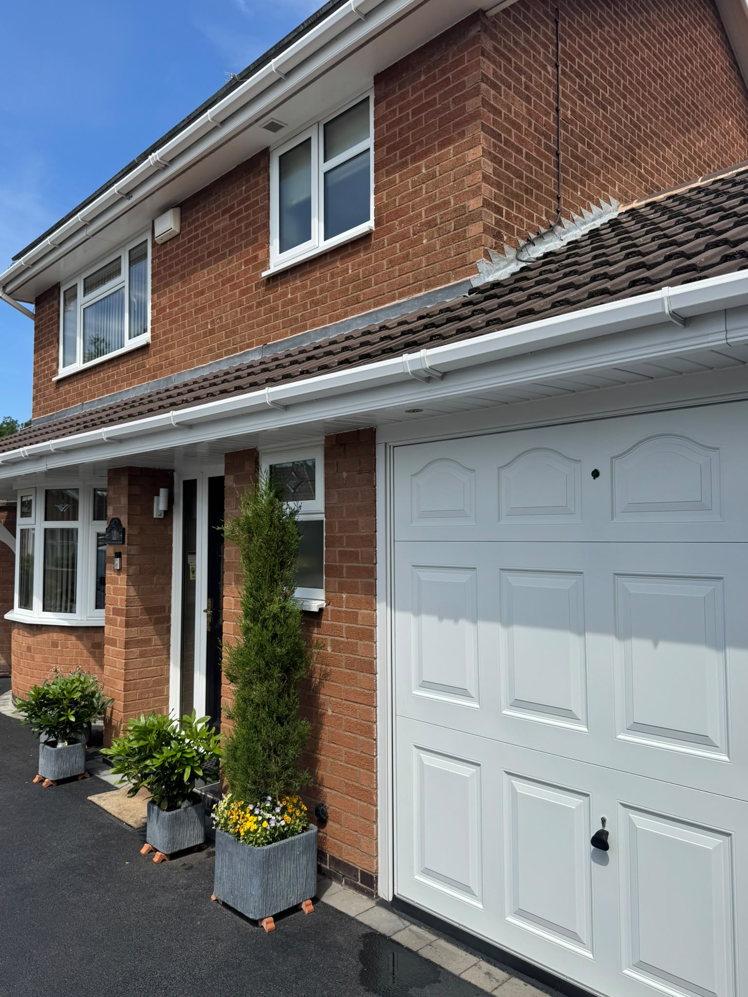 Freshly cleaned front elevation, white fascias and garage door